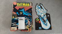 Batman comic book with Silver Surfer cardboard cutout against gray background
