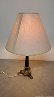 Full view of Mid-Century Modern bronze table lamp with cream fabric shade.