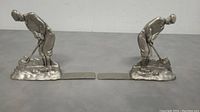 Pair of pewter golf figure bookmarks placed side by side showing both figures leaning forward with putters and elongated flat bookmark sections.