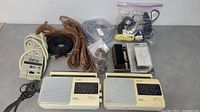 Lot arranged with two Sony portable radios, power bar, various cords, stereo wall mount volume control, and record cleaner brush visible.