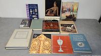 All nine vintage books and two magazines arranged on a surface showcasing their covers and dust jackets, highlighting topics on silver, silversmiths, ceramics, artwork, antiques, and pottery.