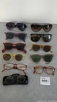 Lot of 11 assorted vintage and modern sunglasses and eyeglasses shown on flat surface, displaying various frame colors and lens tints.