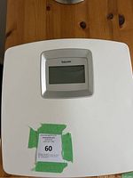 White Beurer digital scale with LCD display screen, placed on wooden surface