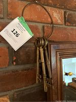 Set of three vintage brass skeleton keys hanging on a brass ring against brick wall