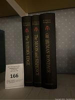 Three vintage hardcover books by W. Somerset Maugham arranged side by side showing spines titled The Razor's Edge, The Moon and Sixpence, and Of Human Bondage.