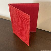 Red croc style leather folio, open to show interior lining and texture