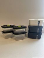 Four clear Foodsaver containers stacked, each with black lid and green vacuum button