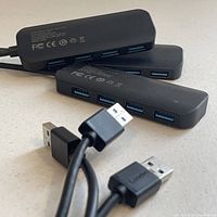 Three Lenovo 4-Port USB 3.0 hubs stacked showing front USB ports and cables.
