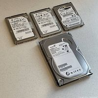 Photo showing five internal SATA hard drives: one 3.5-inch Seagate Barracuda 500GB, two 2.5-inch Seagate Momentus 500GB, one 2.5-inch Toshiba MK5065GSXN 500GB, and one 2.5-inch Seagate Momentus 250GB.