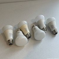 Six Philips Hue smart LED bulbs shown on white surface. Five are the Hue White and Color model, one is the White 800 lumens model.