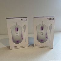 Two Tilted Nation TNGhost RGB Gaming Mouse (White) boxes side by side unopened.