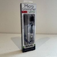 Front view of WAHL MicroGroomsman Lithium trimmer in sealed packaging showing product and included attachments.