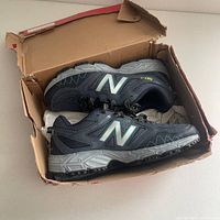 Side view of new Womens New Balance running shoes in box, showing detail on sole and upper.