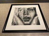 Full framed art print showing the black and white illustration of a close-up face with freckles and the black frame.