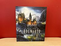 Front cover photo showing the full front artwork of the book titled 'Harry Potter A Pop-Up Guide to Hogwarts' by Matthew Reinhart and illustrated by Kevin M. Wilson.