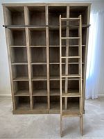 Front view of two bookshelf units assembled side by side with ladder and metal rail