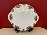 Front view of the Royal Albert Old Country Roses footed gateau plate showing floral pattern and scalloped gold trim