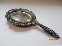 Full view of the antique Victorian hand mirror showing the cloisonné enamel decoration on the frame and handle with the bevelled glass mirror.