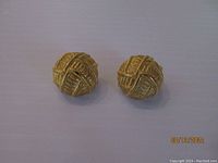 Front view of the pair of vintage Givenchy gold tone clip-on earrings showing the woven textured design.