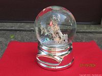 Spherical glass music box with silver-tone base and butterfly design inside.