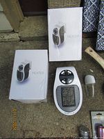 Two white portable heaters, one out of box, two boxes visible, placed on the ground