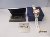 Photo showing the Invicta Reserve watch displayed with original blue box and documentation including booklet and a card.