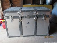 Front of vintage KOWA aluminum trunk showing locks, latches, and riveted metal construction.