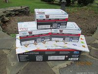Five sealed Elite Trainer Boxes stacked around one Premium Collection box on stone patio outdoors with visible Pokémon branding and Series 151 Snorlax design.