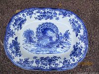 Full view of the blue and white turkey plate with floral border, showcasing the central turkey design and scalloped edges.