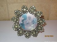 Front view of round rhinestone decorated picture frame with circular photo opening