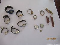 Overview photo displaying multiple wristwatches, a pocket watch, and several watch parts along with extra straps.