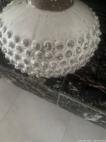 Close-up of the white vase showing the bubble textured surface and rounded shape.