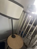 Close-up of the round wooden tabletop with built-in lamp and black metal vertical support.