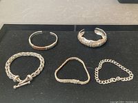 Overview of all five bracelets displayed on black pad