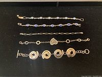 All five bracelets laid out on black background