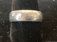 Close-up of the ring band showing the engraved Elvish script from the Lord of the Rings series.