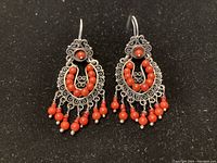 Front view of both earrings showing the detailed silver filigree and red coral bead design.