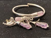 Bracelet and earrings laid together on black background showing amethyst stones and sterling silver details.