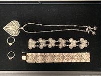 All items displayed: heart pendant necklace, two bracelets, two rings