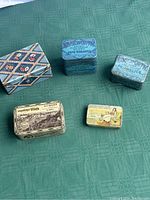 Top-down photo showing all 5 tins with clear text and pattern details