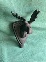 Angled side view showing the detailed antlers and textured cast iron material.