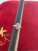 Front view of the 925 silver woman's ring on a black ring sizer, showing the oval-shaped iridescent purple stone.