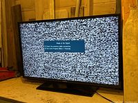 Samsung 42-inch flat screen TV powered on displaying static snow and 'Weak or No Signal' message indicating operational status but no input signal connected.
