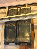 Top-down view showing both black metal car ramps side by side highlighting perforated traction pattern on ramp tops.