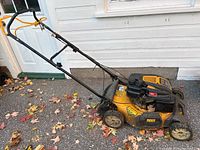 Full side view of yellow and black Cub Cadet lawn mower showing overall condition and structure