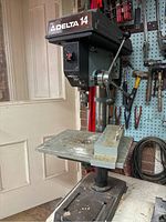 Front view of the Delta 14 drill press showing the drilling table, column, and drill head with controls.