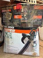 Photo of original Black & Decker Super Vac 'n Mulch product box showing branding and features.