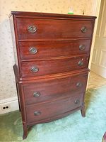 Front view of 5 drawer wooden tallboy dresser showing dark wood finish and metal ring pulls on drawers.