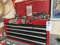 Front view of open red Craftsman toolbox showing top tray contents and measuring tapes