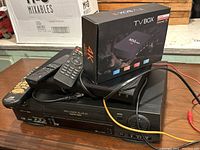 JVC VCR with two remote controls and MCG 4K TV Box on top, cables connected